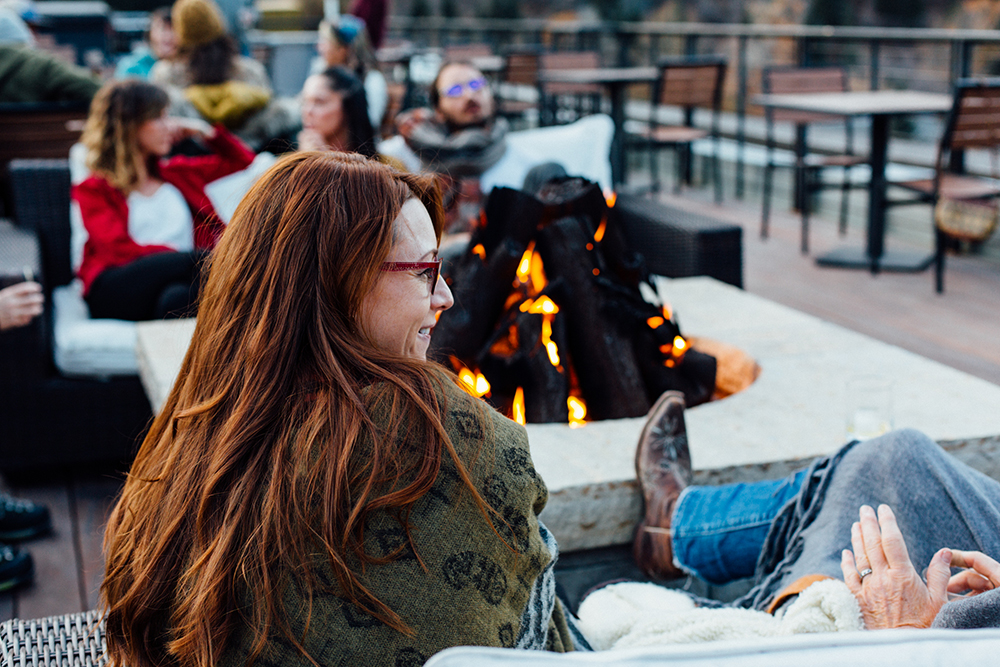 Image of people gathered around the fire socializing at the Imogene rooftop bar.